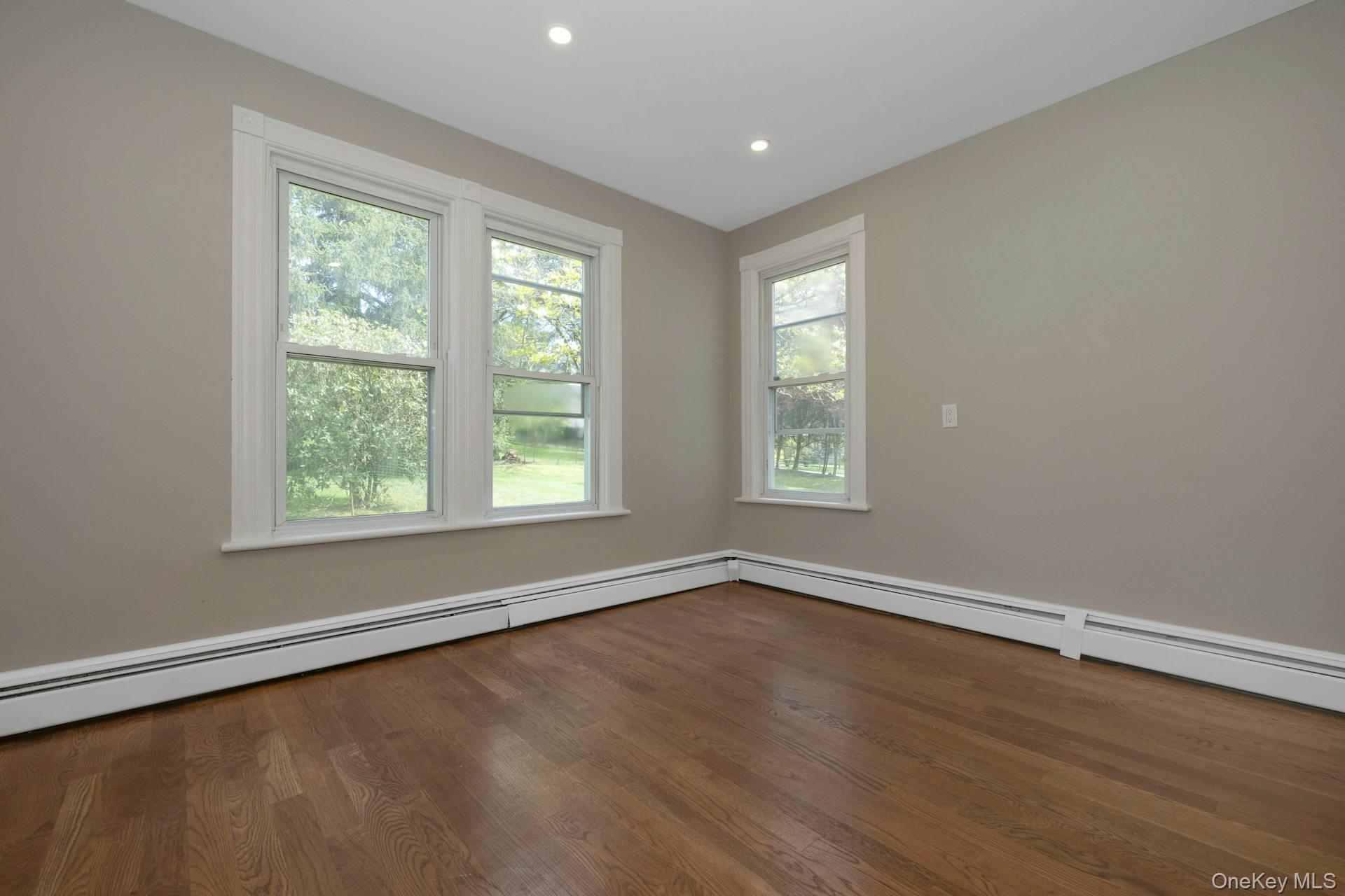 547 King Street, Unit B Chappaqua, NY 10514 - Photo 11 of 19 a view of an empty room with wooden floor and a window