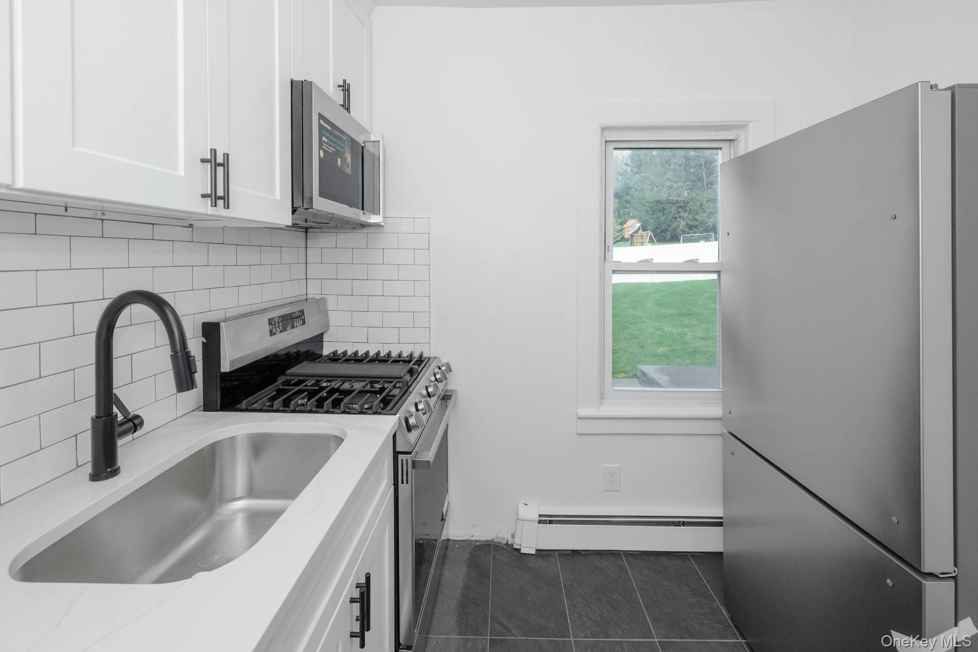 547 King Street, Unit B Chappaqua, NY 10514 - Photo 5 of 19 a kitchen with a sink a stove and cabinets