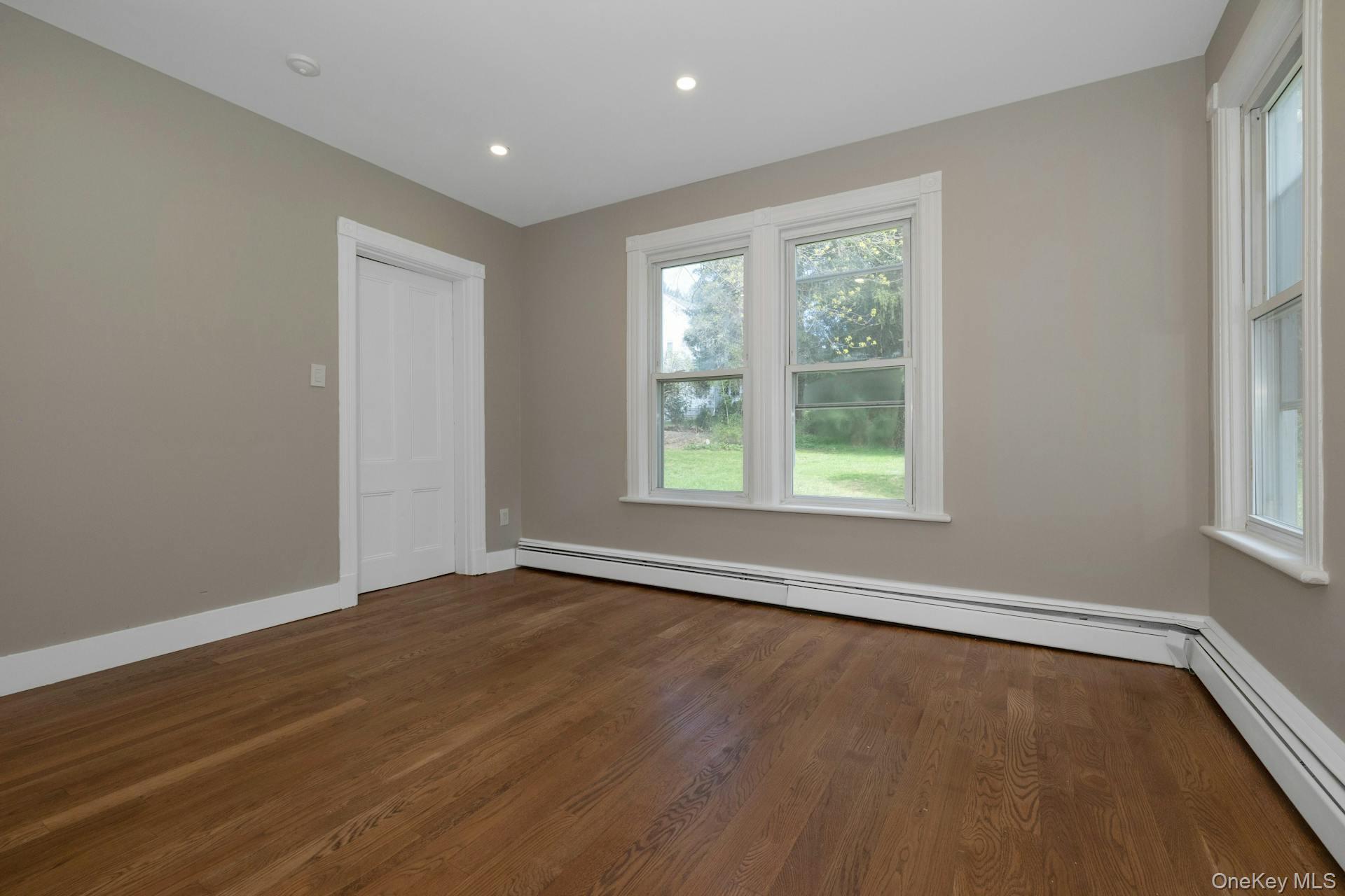 547 King Street, Unit B Chappaqua, NY 10514 - Photo 10 of 19 a view of an empty room with wooden floor and a window