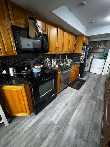 a kitchen with stainless steel appliances a stove a sink and a microwave
