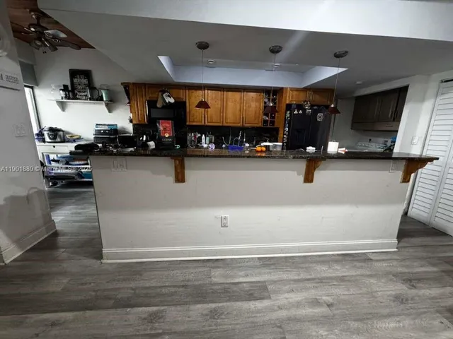 a view of kitchen with stainless steel appliances cabinets and wooden floor