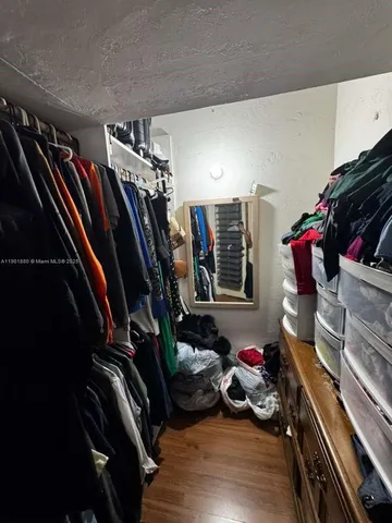 a view of walk in closet with clothes and shoes
