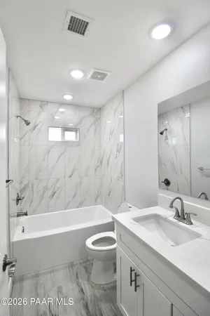 a bathroom with a toilet a sink and glass door