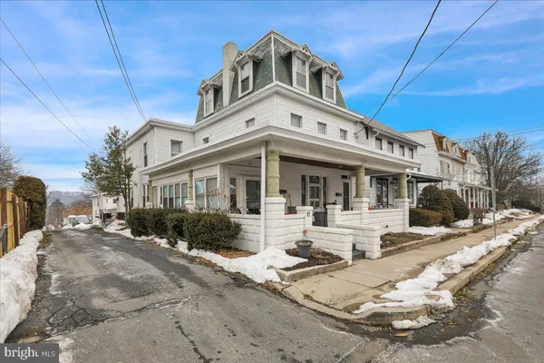a view of a white house with large windows next to a road