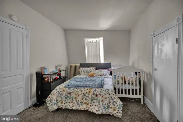 a living room with furniture and a baby crib