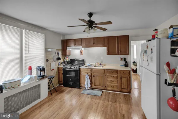 a kitchen with refrigerator a stove and wooden floor