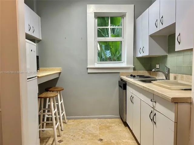 a kitchen with a sink cabinets and a window