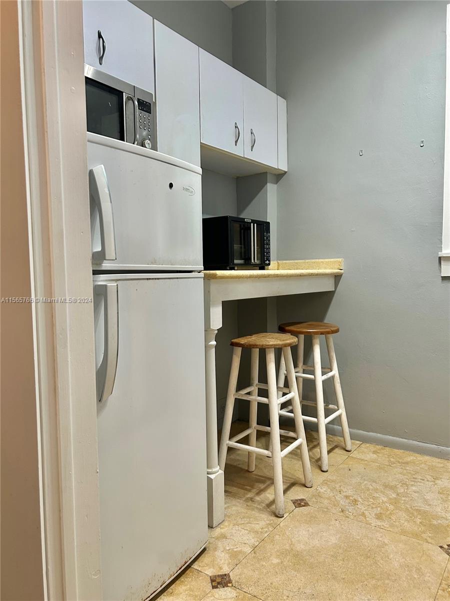 536 14th Street, Unit 107 Miami Beach, FL 33139 - Photo 9 of 13 a kitchen with stainless steel appliances a refrigerator and microwave
