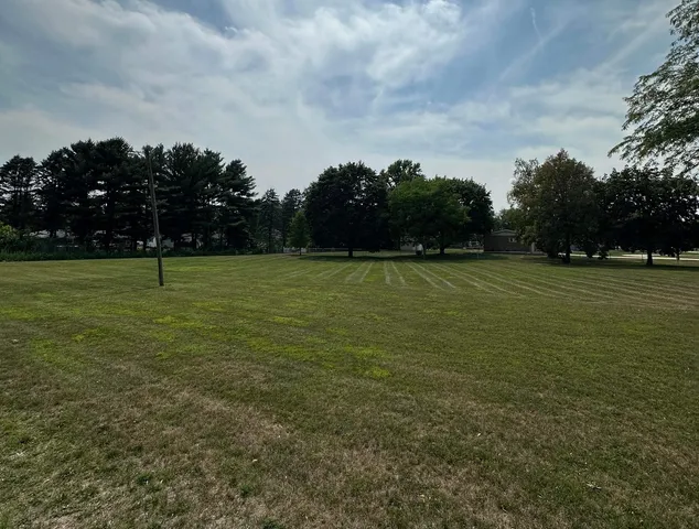 a view of a field with an trees in the background