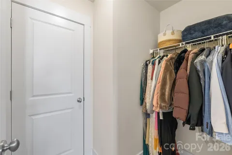 a view of walk in closet with clothes and shoes