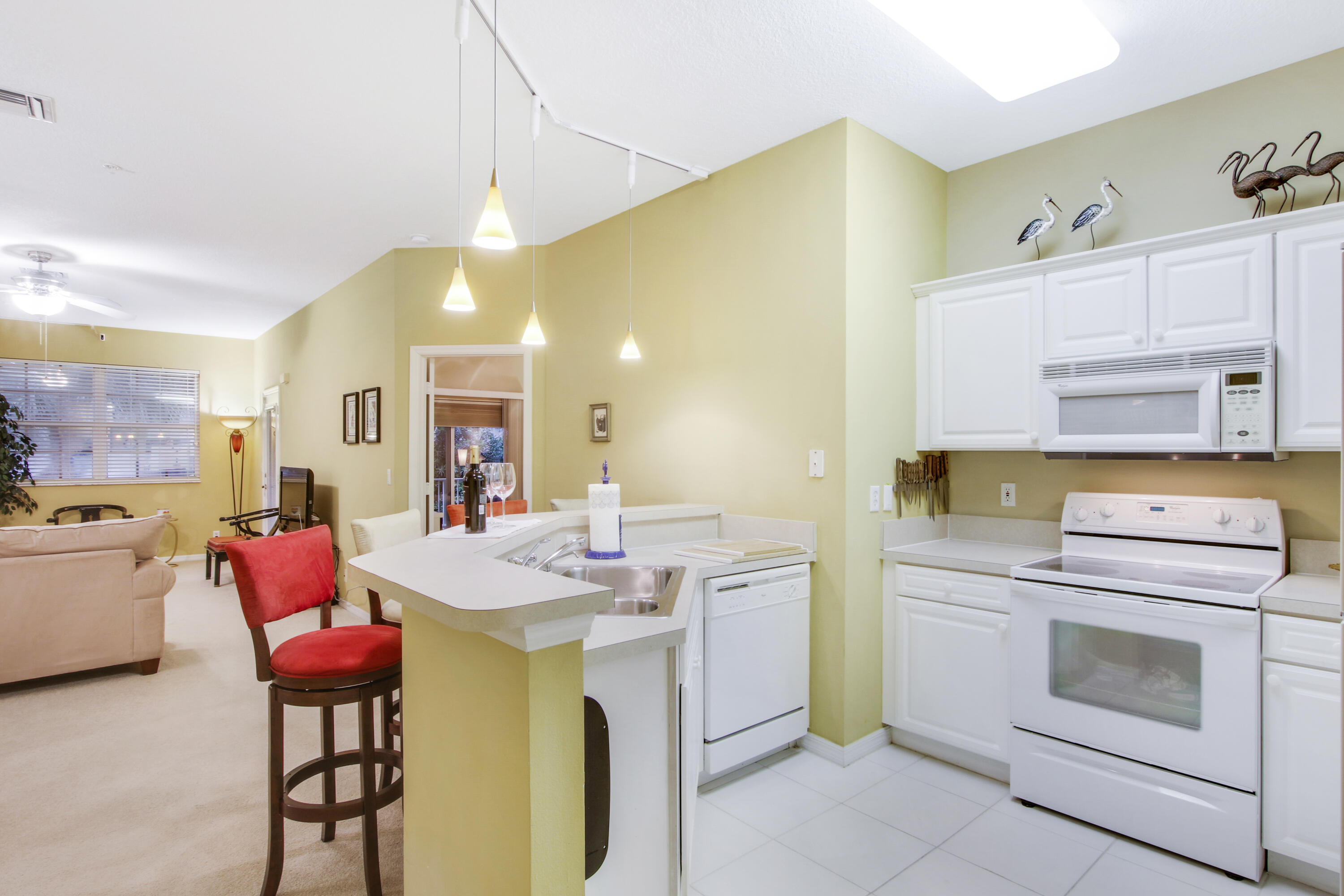 108 Lighthouse Circle, Unit B Jupiter, FL 33469 - Photo 13 of 33 a kitchen that has a stove and a table in it