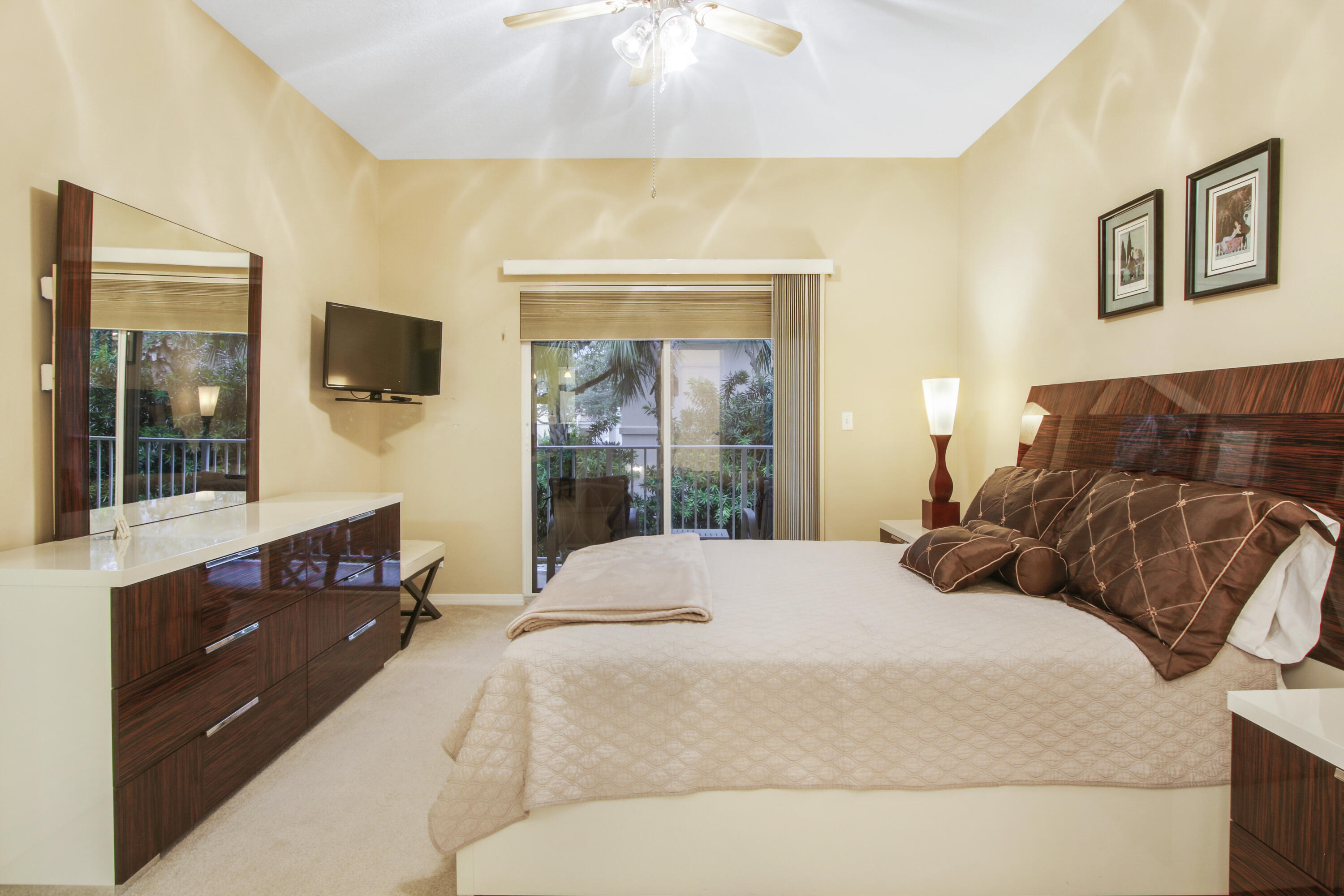 108 Lighthouse Circle, Unit B Jupiter, FL 33469 - Photo 19 of 33 a bedroom with a bed and a flat tv screen on dresser