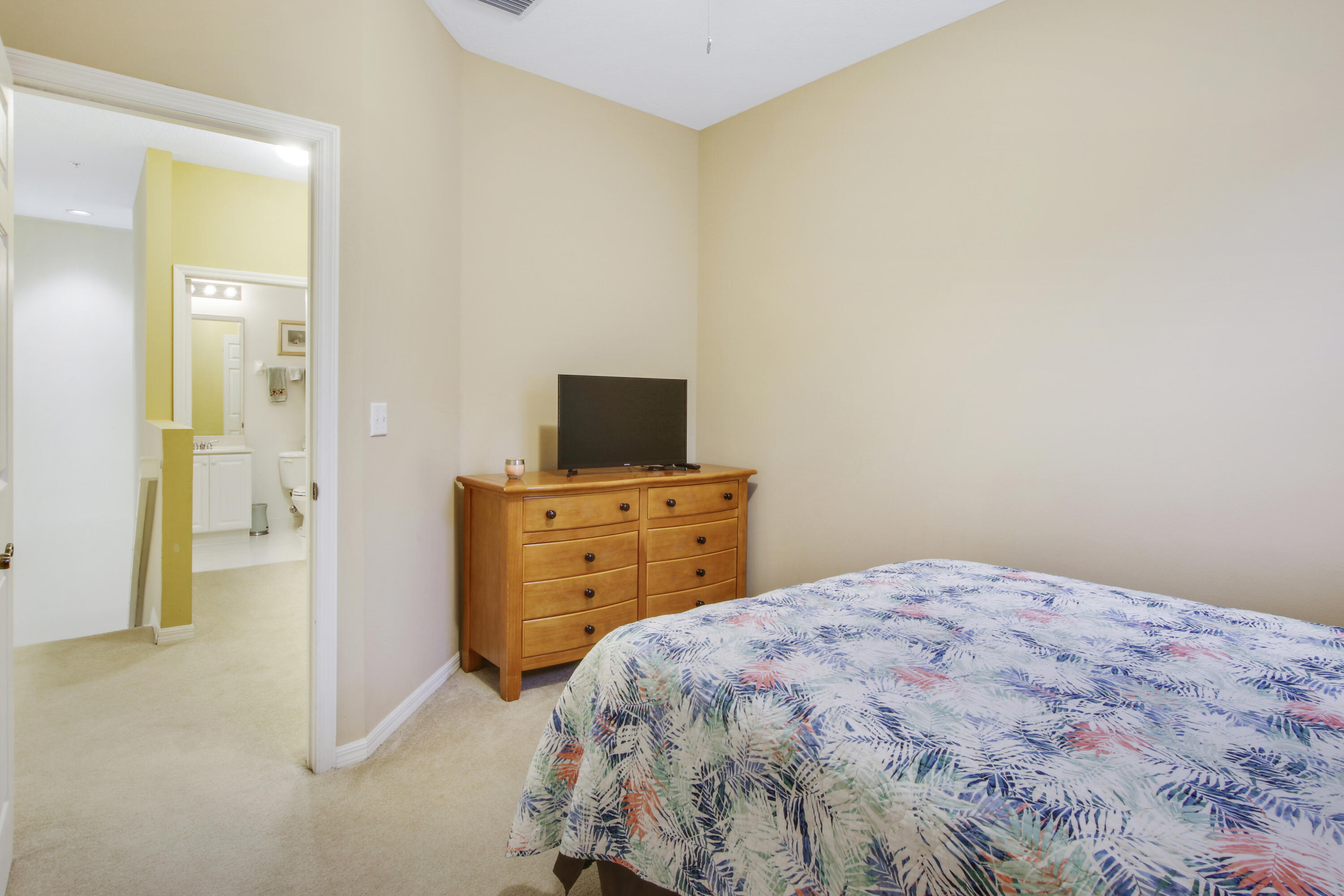 108 Lighthouse Circle, Unit B Jupiter, FL 33469 - Photo 23 of 33 a bedroom with a bed and wooden floor