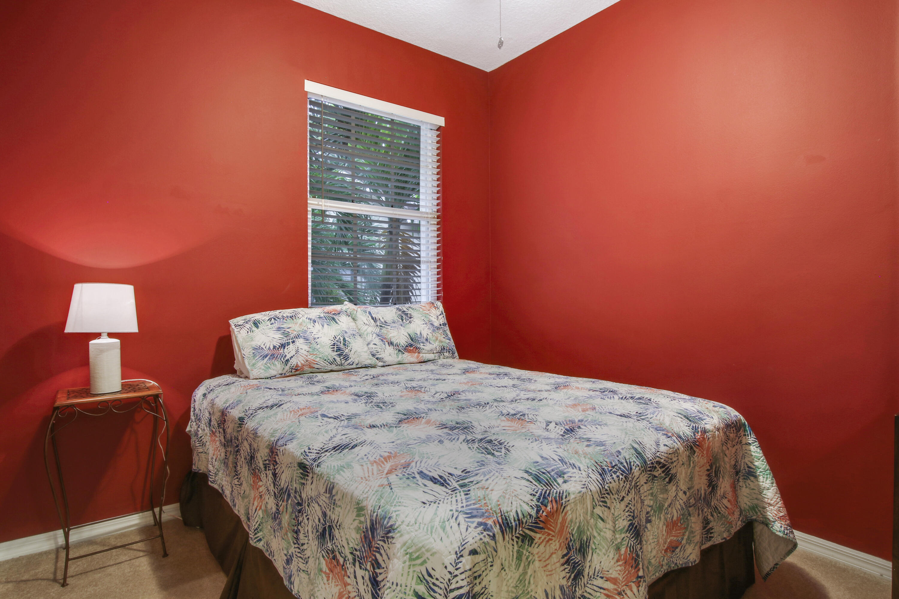 108 Lighthouse Circle, Unit B Jupiter, FL 33469 - Photo 24 of 33 a bedroom with a bed and a lamp