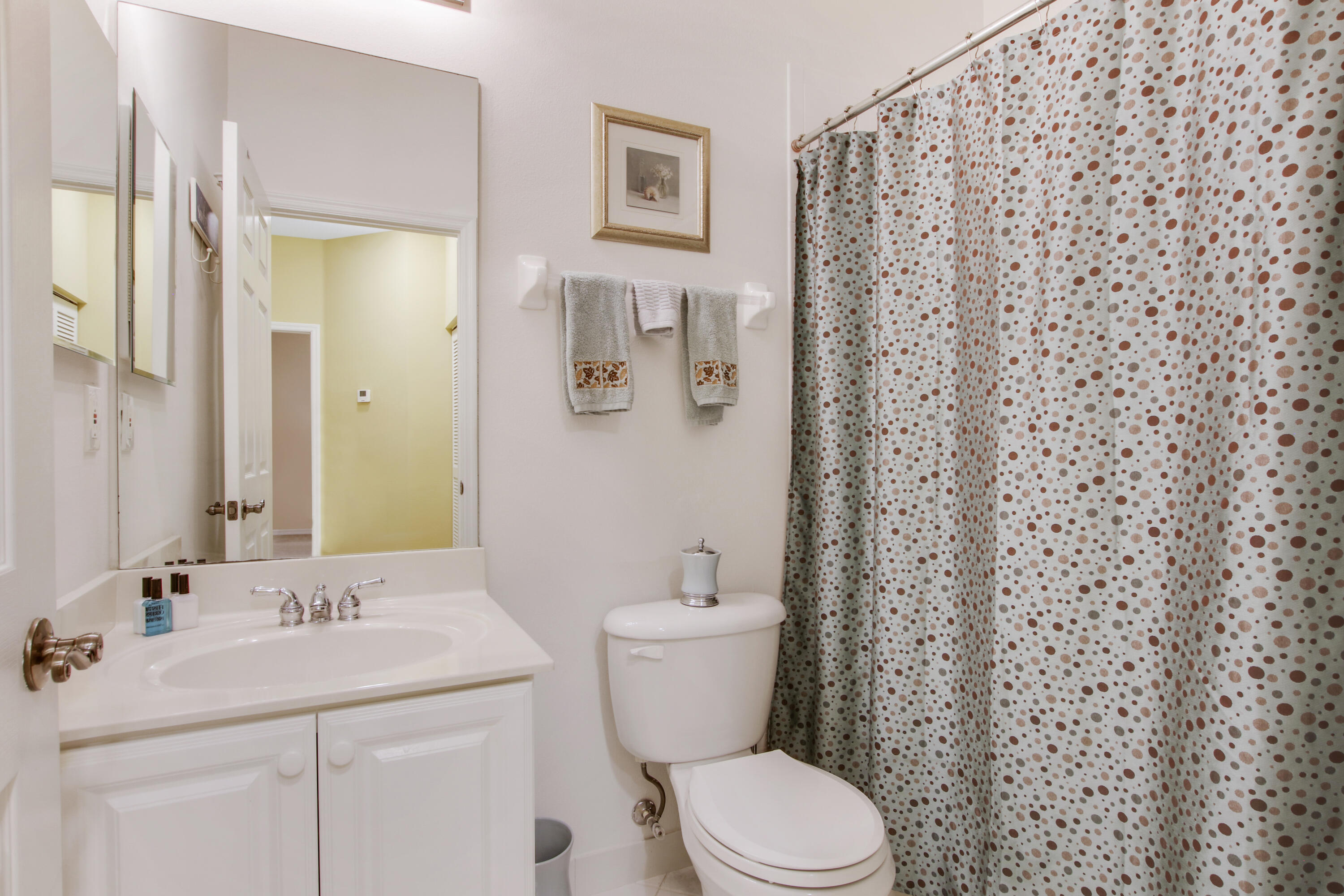 108 Lighthouse Circle, Unit B Jupiter, FL 33469 - Photo 25 of 33 a bathroom with a granite countertop toilet a sink and a mirror