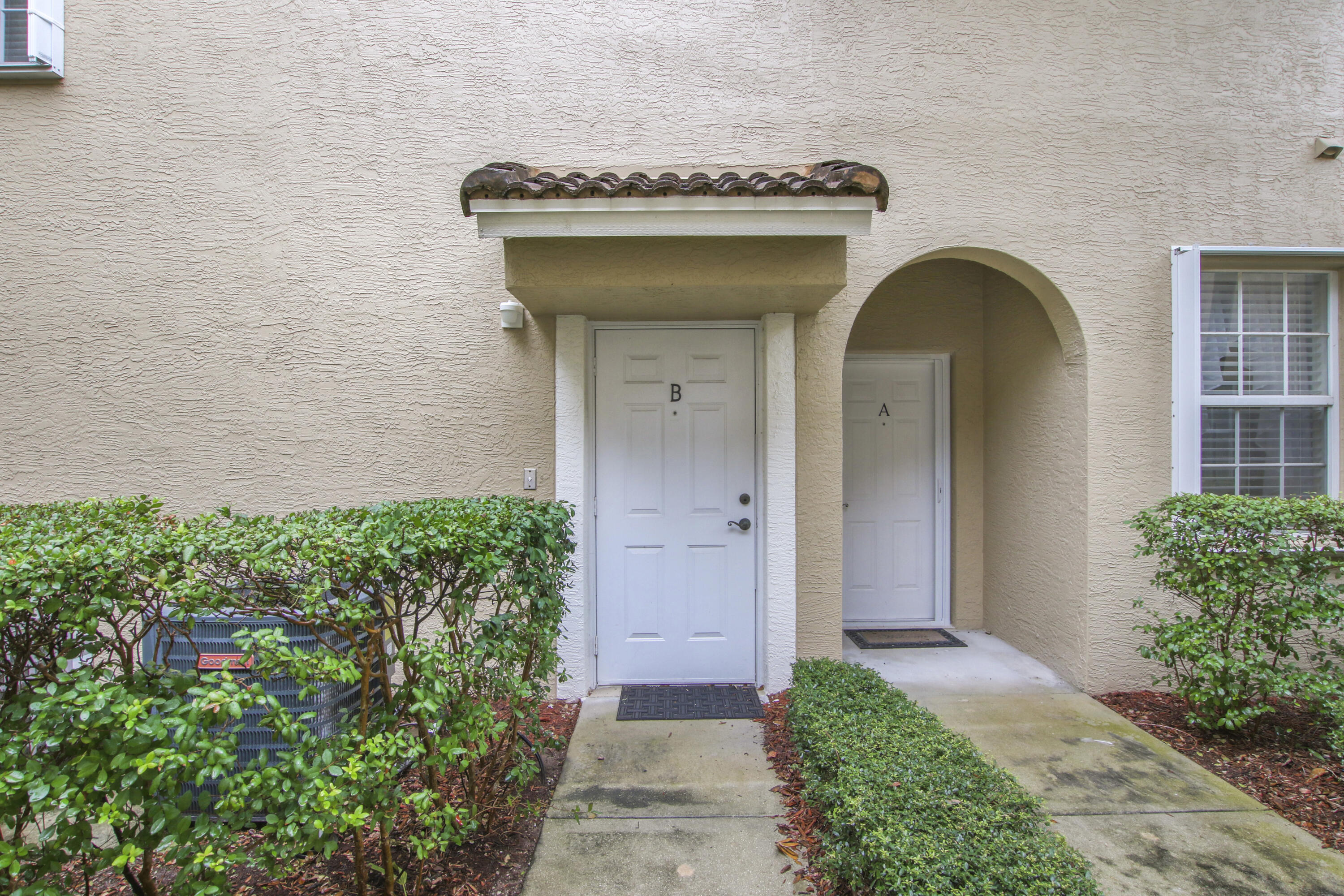 108 Lighthouse Circle, Unit B Jupiter, FL 33469 - Photo 4 of 33 a front view of a house with garden