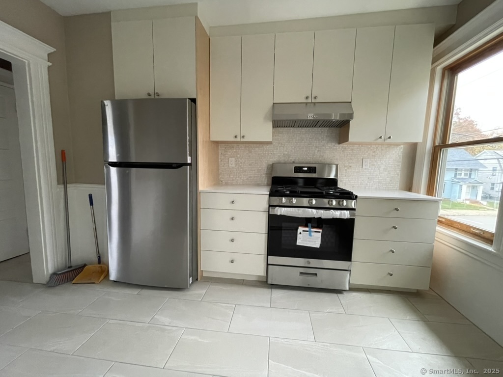 174 Fairview Avenue, Unit 1 Bridgeport, CT 06606 - Photo 2 of 9 a kitchen with refrigerator a stove a microwave and cabinets