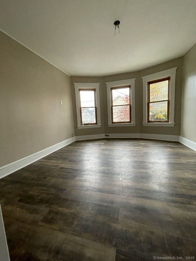 174 Fairview Avenue, Unit 1 Bridgeport, CT 06606 - Photo 7 of 9 an empty room with wooden floor and windows