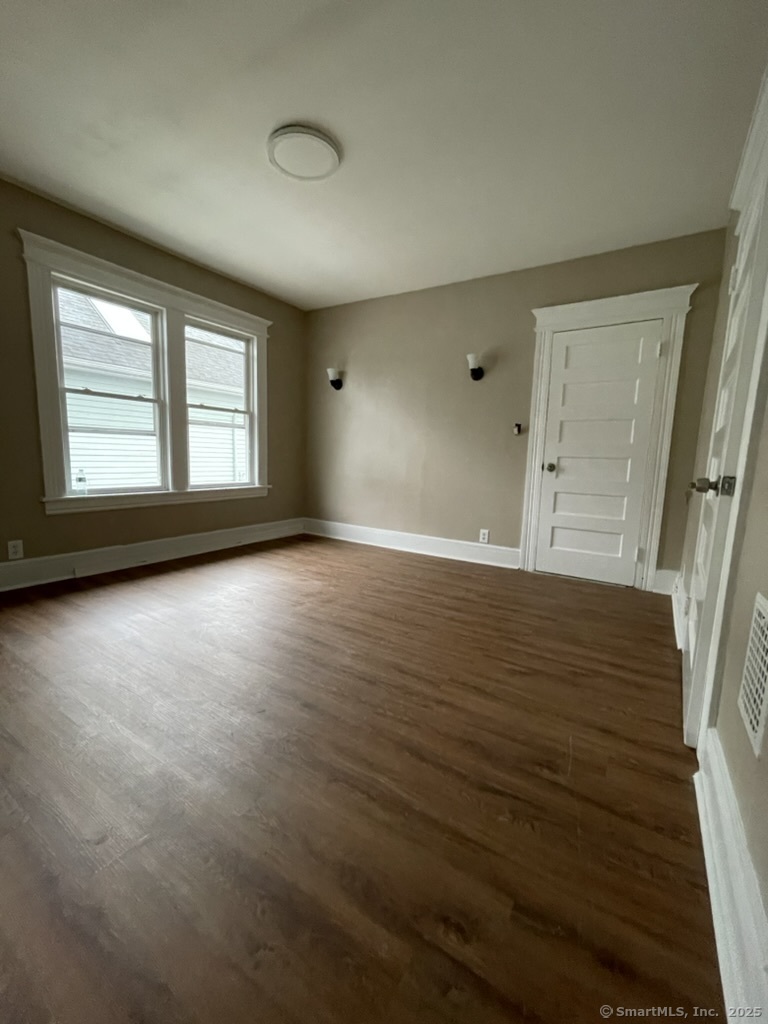 174 Fairview Avenue, Unit 1 Bridgeport, CT 06606 - Photo 8 of 9 a view of an empty room with a window and wooden floor