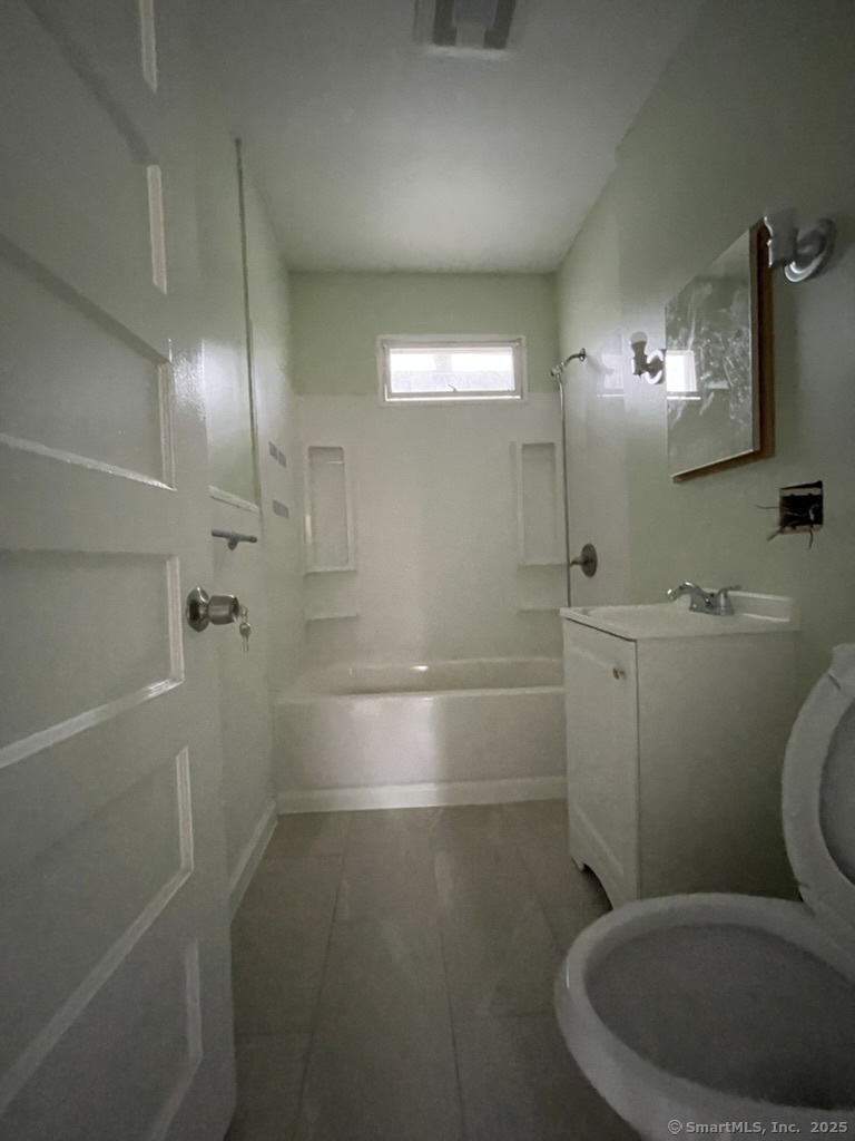 174 Fairview Avenue, Unit 1 Bridgeport, CT 06606 - Photo 9 of 9 a bathroom with a toilet a sink and mirror