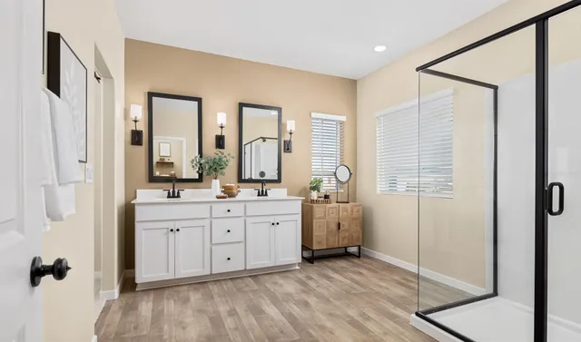 a spacious bathroom with a double vanity sink a mirror and a bathtub