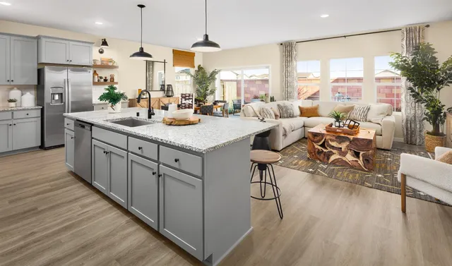 a kitchen with counter top space a sink appliances and wooden floor