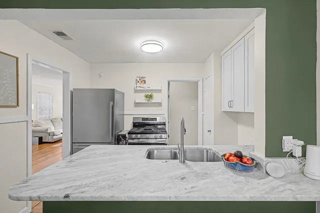 a kitchen with stainless steel appliances granite countertop a refrigerator and a stove