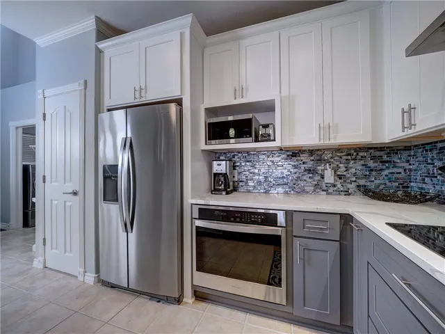 a kitchen with stainless steel appliances kitchen island granite countertop a refrigerator and a stove top oven