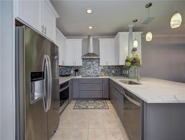 a kitchen with stainless steel appliances granite countertop a sink and a refrigerator