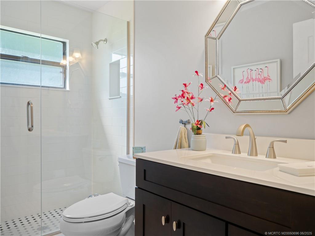 5692 Southeast Lamay Drive Stuart, FL 34997 - Photo 21 of 28 a bathroom with a sink vanity mirror and toilet