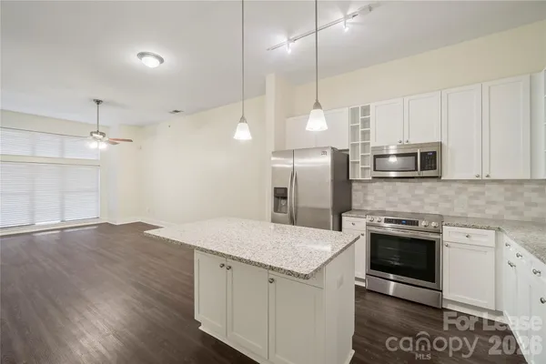 a kitchen with a sink a counter top space stainless steel appliances and cabinets