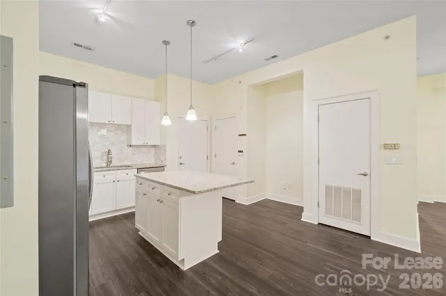a kitchen with a sink a stove a refrigerator and white cabinets