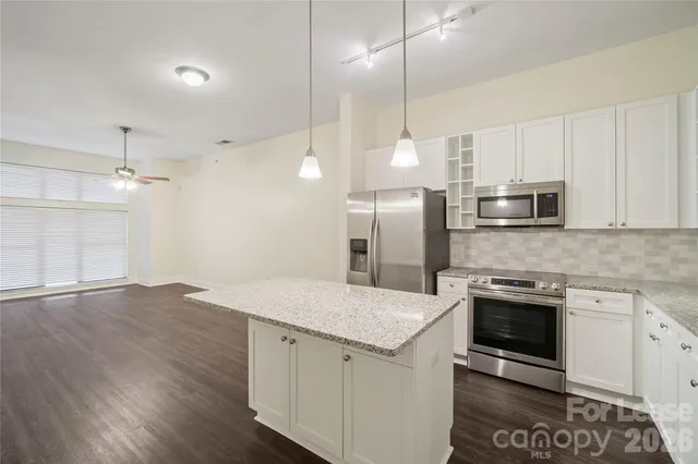 a kitchen with a sink a counter top space stainless steel appliances and cabinets
