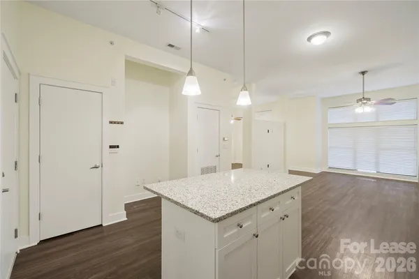 an empty room with wooden floor and ceiling fan