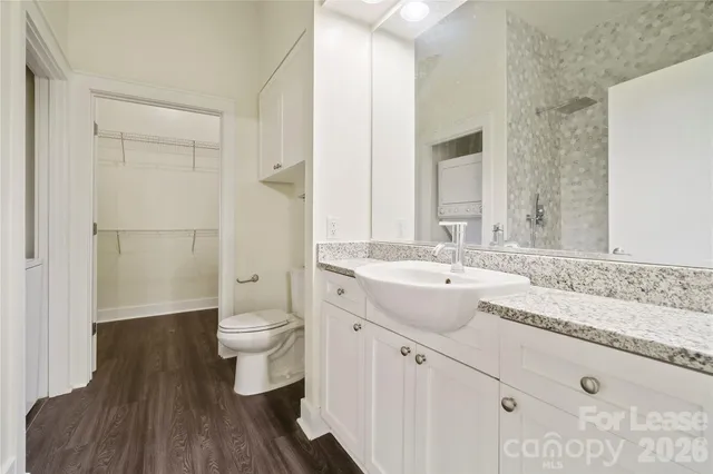 a bathroom with a granite countertop sink a toilet and shower