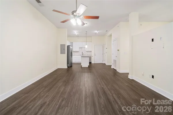 a view of a room with wooden floor and a ceiling fan
