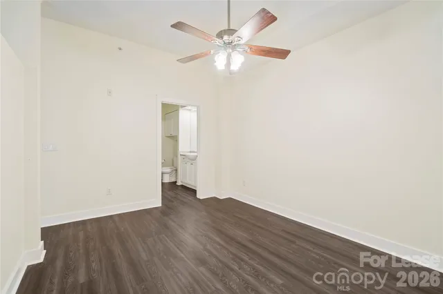 an empty room with wooden floor and a ceiling fan