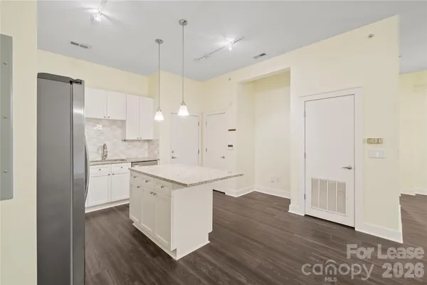 a kitchen with a sink a stove a refrigerator and white cabinets
