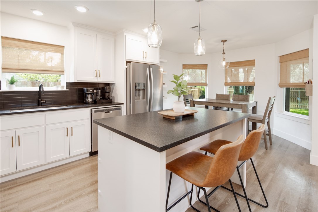 4700 Kensington Road Bryan, TX 77802 - Photo 10 of 31 Contemporary kitchen featuring island with seating for 2 with recessed and pendant lighting