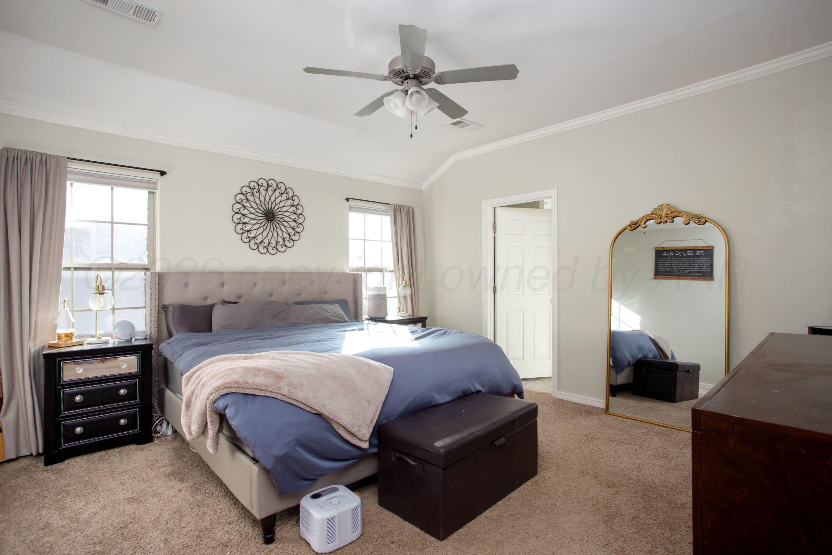 9505 Perry Avenue Amarillo, TX 79119 - Photo 11 of 21 a bedroom with a bed and a chandelier