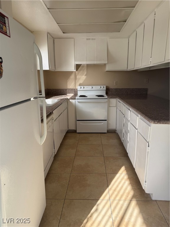4689 West Sand Creek Avenue, Unit C Las Vegas, NV 89103 - Photo 4 of 14 Kitchen featuring white cabinetry, white range oven, fridge, and light tile patterned floors