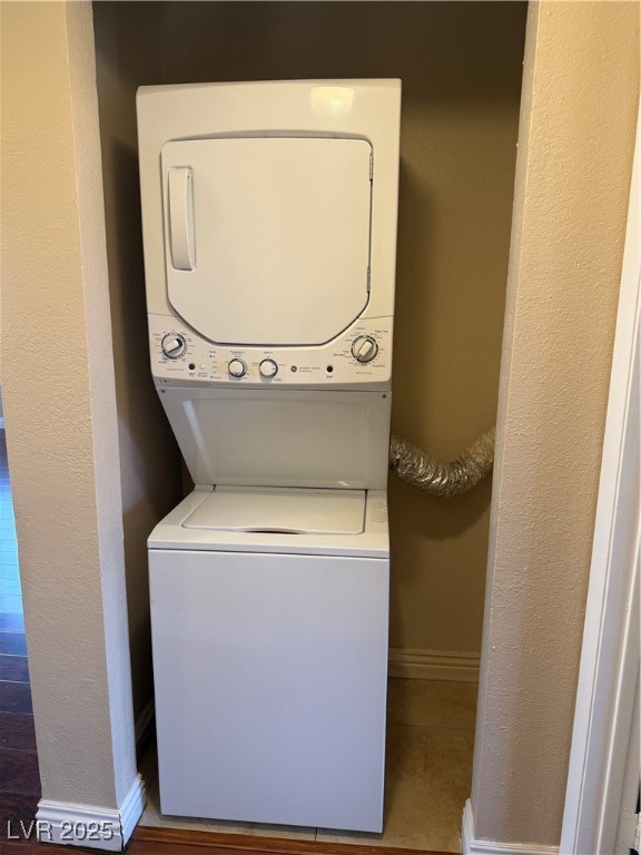 4689 West Sand Creek Avenue, Unit C Las Vegas, NV 89103 - Photo 6 of 14 Washroom featuring a textured wall and stacked washing machine and dryer