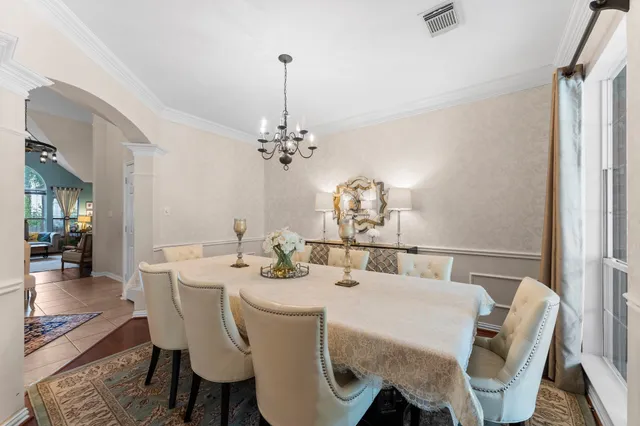 a dining room with furniture a chandelier and wooden floor