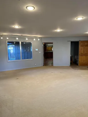 a view of an empty room with a kitchen