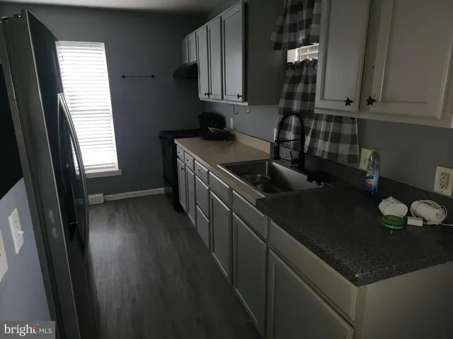 a kitchen with granite countertop a sink stove and cabinets