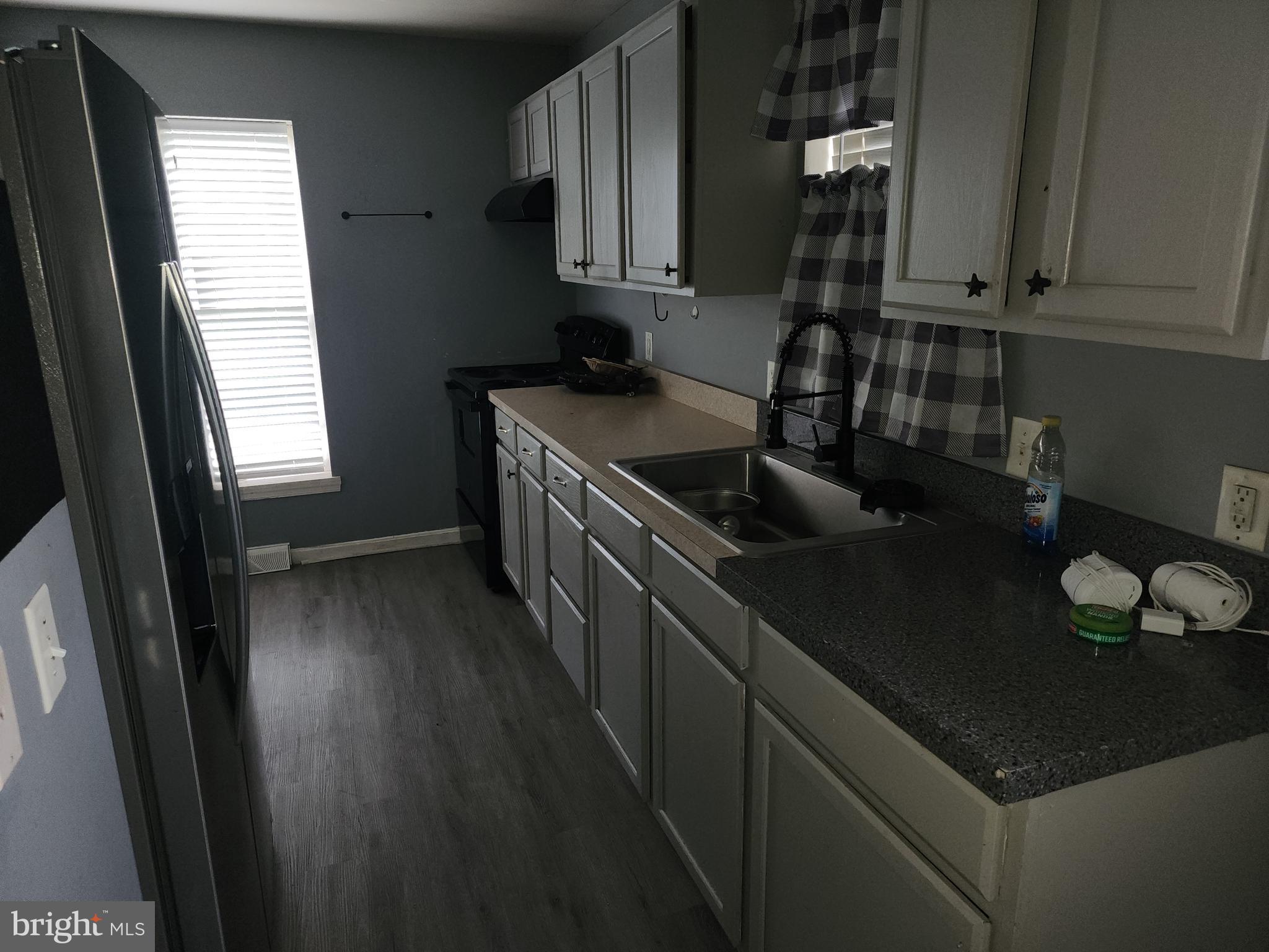 114 Spruance Road Dover, DE 19901 - Photo 4 of 12 a kitchen with granite countertop a sink stove and cabinets