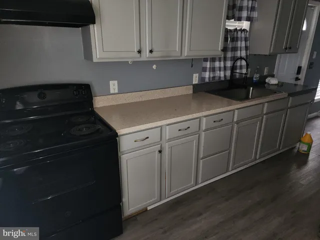 a kitchen with granite countertop white cabinets and black appliances