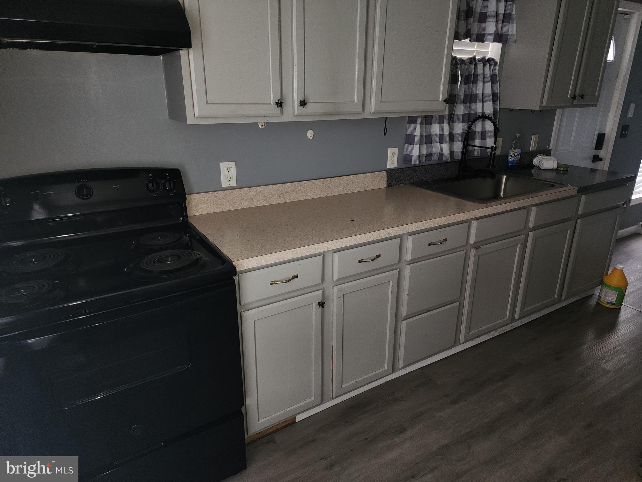 114 Spruance Road Dover, DE 19901 - Photo 5 of 12 a kitchen with granite countertop white cabinets and black appliances
