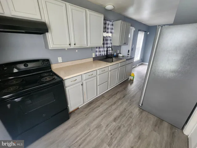 a kitchen with a sink a stove and cabinets