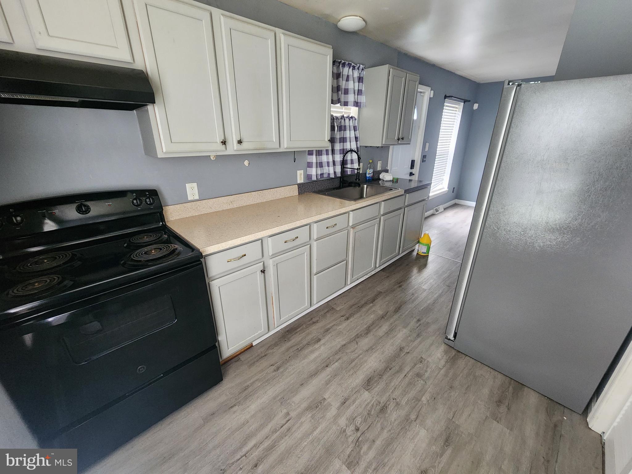114 Spruance Road Dover, DE 19901 - Photo 6 of 12 a kitchen with a sink a stove and cabinets